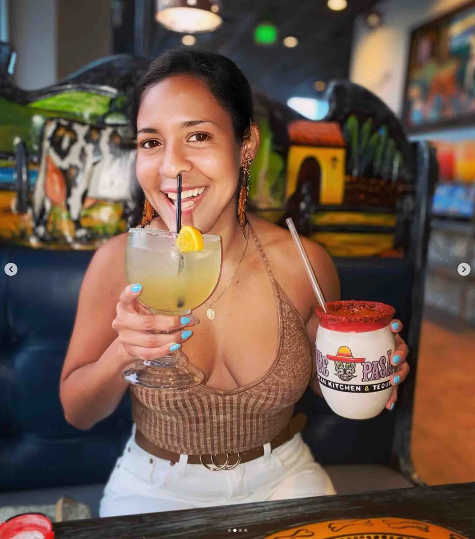 A guest raising a margarita at Que Pasa