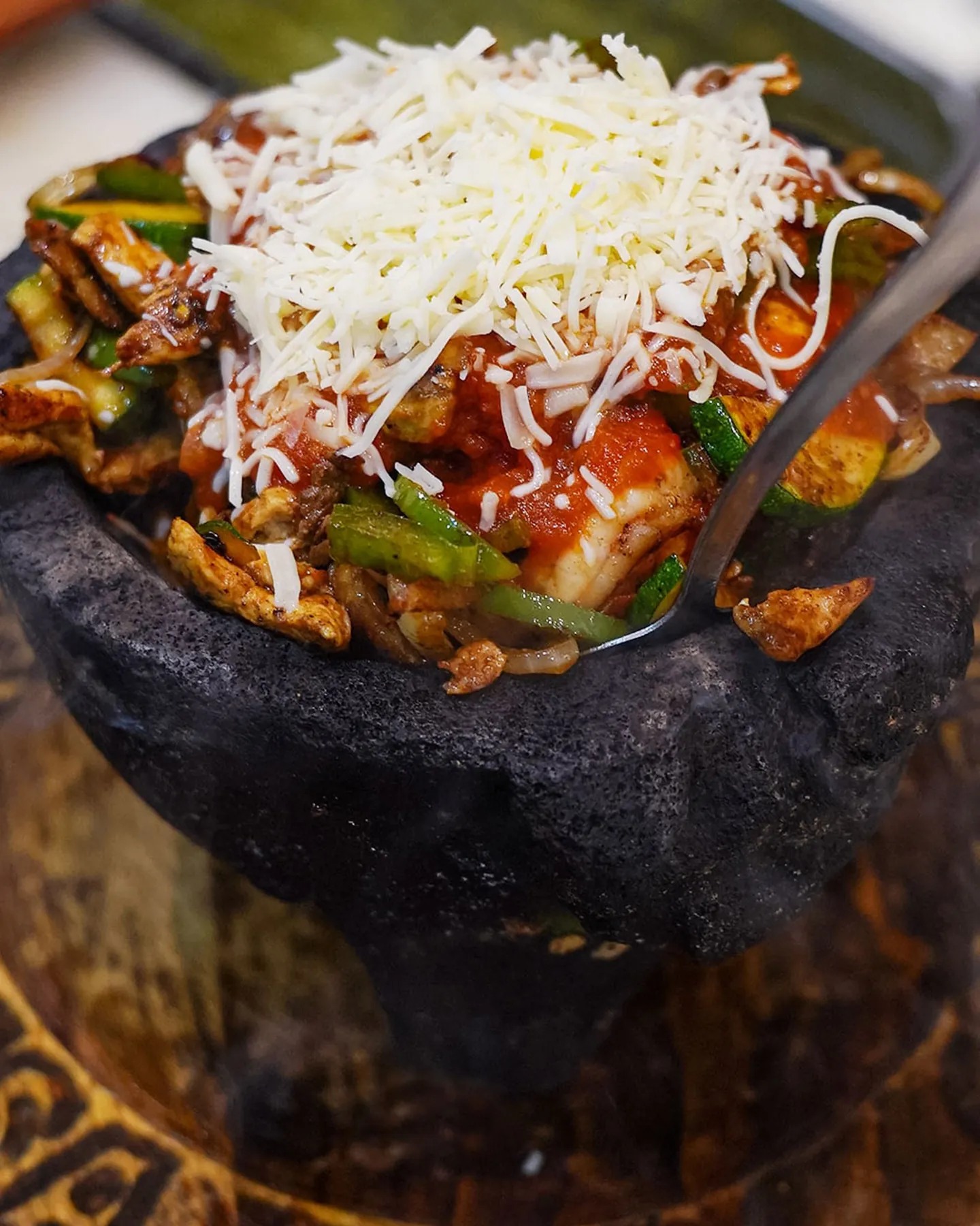 A sizzling molcajete topped with cheese